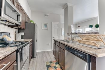A kitchen with a black fridge and a black stove top oven.